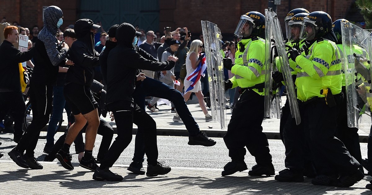 Police officers face protesters outside the Liver Building in Liverpool on August 3, 2024 during the 'Enough is Enough' demonstration held in reaction to the fatal stabbings in Southport on July 29 2024.